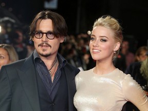 In this Nov. 3, 2011 file photo, U.S. actors Johnny Depp, left, and Amber Heard arrive for the European premiere of their film, "The Rum Diary," in London. A Los Angeles judge on Tuesday, Aug. 9, 2016, ordered a delay in a restraining order hearing that will address Heard's allegations that Depp  physically abused her during a fight in May. (AP Photo/Joel Ryan, File)
