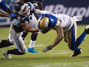 Toronto Argonauts defensive back Devin Smith (19) tackles Winnipeg Blue Bombers wide receiver Jace Davis (1) during second half CFL football action in Toronto on Friday, August 12, 2016. (THE CANADIAN PRESS/Nathan Denette)