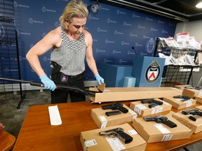 Det.-Const. Nadine Teeft  of the Gun and Gang Task Force packages up a rifle seized in Project Sizzle on June 3, 2016. (Jack Boland/Toronto Sun)