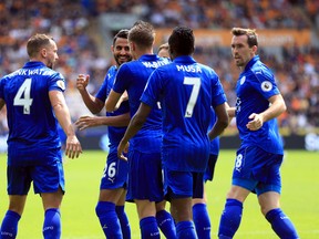Leicester City's Riyad Mahrez of France, second left, celebrates scoring his side's first goal of the game from the penalty spot during the Premier League soccer match at the KCOM Stadium, Hull, England, Saturday Aug. 13, 2016. (Nigel French/PA via AP)