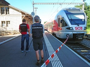 Policemen stand by a train at the station in Salez, eastern Switzerland, after a man set a fire and stabbed passengers on August 13, 2016. A man set a train carriage in Switzerland on fire using a flammable liquid and stabbed passengers, injuring six people including a six-year-old child, police said. (AFP PHOTO/NEWSPICTURES.CH/BEAT KAELIN"BEAT KAELIN/AFP/Getty Images)