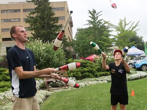 Gage Sheffield, 10, of Sarnia learns to juggle alongside Stilt Guys co-founder Kyle Sipkens at a riverfront workshop Saturday at the sixth annual Sarnia/Port Huron International Powerboat Festival. The festival included music, powerboat races, boat displays, a kids' zone and other attractions. Tyler Kula/Sarnia Observer/Postmedia Network