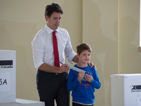 Justin Trudeau walks with his son Xavier to the ballot box after filling in his ballot at a polling station in Montreal Monday, October 19, 2015 in the federal election. (THE CANADIAN PRESS/Adrian Wyld)