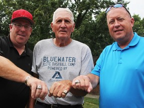 Larry Downes, left, and Tom Nelson, right, players for Team Canada at the 1984 Olympics, pose in Corunna alongside team manager Eric Mackenzie. Downes and Nelson surprised Mackenzie with a ring Sunday, commemorating the team's stint at the games. Several players also recently ordered similar rings. (Tyler Kula/Sarnia Observer)
