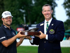 Ryan Moore and Tournament Chairman Paul Scranton hold the trophy during the final round of the John Deere Classic at TPC Deere Run on August 14, 2016 in Silvis, Illinois.  (Photo by Michael Cohen/Getty Images)