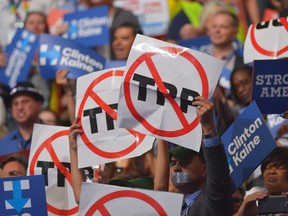 People hold signs against the Trans Pacific Partnership (TPP) on Day 3 of the Democratic National Convention at the Wells Fargo Center, July 27, 2016 in Philadelphia, Pennsylvania. (MANDEL NGAN/AFP/Getty Images)