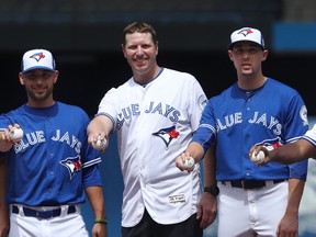 Former Blue Jays pitcher Roy Halladay (centre) posed with Marco Estrada (left) and Aaron Sanchez (right) during a pregame ceremony on Aug. 14, 2016 at Rogers Centre. (TOM SZCZERBOWSKI/Getty Images)