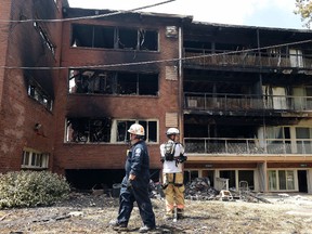 In this Thursday, Aug. 11, 2016, file photo, emergency personnel view the scene of an apartment building fire in Silver Spring, Md. A fourth body was recovered after an explosion and fire at an apartment complex in Maryland, authorities said Sunday, Aug. 14, 2016, as firefighters continued to comb through the rubble to search for several others who remain missing. (AP Photo/Susan Walsh, File)