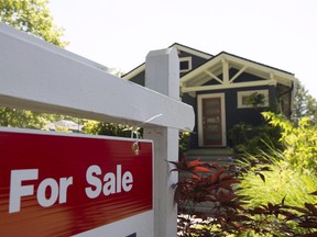 The Canadian Real Estate Association says July marked the third consecutive month of fewer housing sales. A for sale sign is pictured outside a home in Vancouver in a June, 28, 2016, file photo. (THE CANADIAN PRESS/Jonathan Hayward, File)
