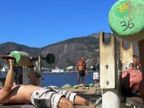 Men lift stone weights at at outdoor gym in Rio de Janeiro, Brazil, Sunday, Aug. 14, 2016. It’s a given that Olympic athletes have chiseled muscles, but in Rio, tourists here for the games can’t help but notice that there are plenty of non-Olympians with the bodies of gods. (AP Photo/Peter Prengaman)