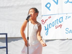 Eight-year-old Yoona Lin sings in downtown Evansburg during Pembina Valley Daze