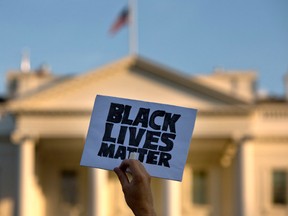 In this July 8, 2016 file photo, a man holds up a sign saying "black lives matter" during a protest of shootings by police, at the White House in Washington.  (AP Photo/Jacquelyn Martin)