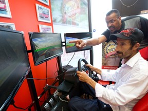 Fanshawe Driving School instructor Zafir Ahmed helps Syrian refugee Almohamad Yasser use a driving simulator Monday in the school?s Southdale Road office in London. More than 60 refugees, including Yasser, have signed up for a G2 driving class exclusively for Arab speakers.(CRAIG GLOVER, The London Free Press)