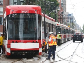 A lineup of streetcars after a new, empty TTC streetcar derailed while pushing an older streetcar at King and Bathurst on Tuesday August 16, 2016. (Michael Peake/Toronto Sun)
