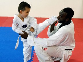 Jason Li, a five-year-old white belt, works on his kicking with Master Jason McIntyre at the Sarnia Olympic Taekwondo Academy. The academy is launching the area's first after-school martial arts education program this fall, with school pickup included in the registration fee. (Handout/Sarnia Observer/Postmedia Network)