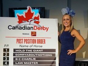 Northlands employee Devan Twynam puts up the post position order of the horses competing at The Canadian Derby at Northlands Racetrack on Saturday. (Larry Wong)