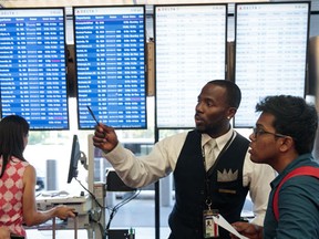 A Delta employee helps travelers near the Delta check-in counter at LaGuardia Airport , August 8, 2016 in the Queens borough of New York City. Delta flights around the globe were grounded and delayed on Monday morning due to a system outage. (Drew Angerer/Getty Images)