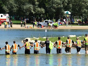 Searchers linked arm-in-arm search the water at Birds Hill Provincial Park near Winnipeg on Wed., Aug. 17, 2016 after a beach safety officer thought she saw someone go under and not resurface. Kevin King/Winnipeg Sun/Postmedia Network