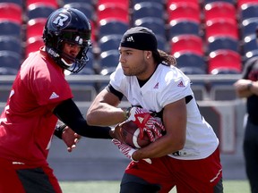 Henry Burris (left) hands off to Redblacks running back Kienan LaFrance at practice. (Tony Caldwell, Ottawa Sun)