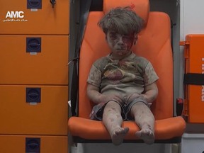 In this frame grab taken from video provided by the Syrian anti-government activist group Aleppo Media Center (AMC), a child sits in an ambulance after being pulled out of a building hit by an airstrike, in Aleppo, Syria, Wednesday, Aug. 17, 2016. (Aleppo Media Center via AP)
