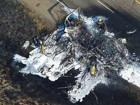 In this aerial view photo taken, Wednesday, Aug.17, 2016,  fire fighters work at the wreckage of a truck that burned and closed Interstate 94 near Huntley, Mont.  (Larry Mayer/The Billings Gazette via AP)