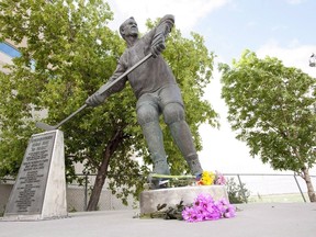 Flowers are placed at a statue of Gordie Howe at the Sasktel Centre in Saskatoon, Friday, June 10, 2016. A city official says the family of the hockey great has requested that the cremated remains of Howe and his wife Colleen be interred at the base of a statue that honours him in Saskatoon. (THE CANADIAN PRESS/Liam Richards)