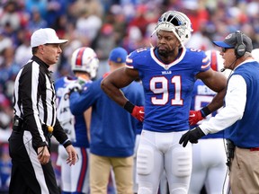 Buffalo Bills outside linebacker Manny Lawson looks on as head coach Rex Ryan, right, talks to referee Tony Corrente during the first half of an NFL football game against the Houston Texans, Sunday, Dec. 6, 2015, in Orchard Park, N.Y. (AP Photo/Gary Wiepert)