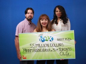 Toronto's Miriam Bueno poses with her novelty cheque from her $55-million Lotto Max win with her son Richard Streit and daughter Diana Aldama in this OLG handout photo.