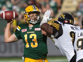 Edmonton Eskimos quarterback Mike Reilly (13) makes a throw against the Hamilton Tiger-Cats in Edmonton, Alta., on Saturday July 23, 2016. (THE CANADIAN PRESS/Jason Franson)