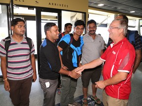 Alex Gryska, right, of the International Mines Rescue Body, greets members of a mine rescue team from India at the Greater Sudbury Airport in Greater Sudbury, Ont. on Thursday August 18, 2016. A total of 27 teams from around the world are competing at the International Mines Rescue Competition in Greater Sudbury from Aug. 19-26.  John Lappa/Sudbury Star/Postmedia Network