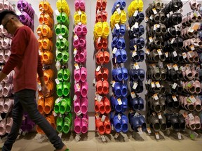 In this April 9, 2010, file photo, Summett Kumar, a Crocs ambassador, works at Crocs store inside the Beverly Center shopping mall in Los Angeles. A Texas couple is suing footwear maker Crocs and a Waikiki resort after their 2-year-old son's foot got caught in an escalator while the family visited Hawaii in 2014 for an oral surgeon convention. According to the lawsuit, the escalator "completely de-gloved" the toddler's left foot, requiring emergency surgery. (AP Photo/Damian Dovarganes, File)
