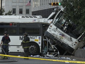 Emergency crews respond to the scene of a accident involving two commuter buses in Newark, N.J., on Friday, Aug. 19, 2016.  Investigators are trying to determine if a commuter bus ran a red light and broadsided another commuter bus, killing a driver and injuring several.  (Bob Sciarrino/NJ Advance Media via AP)