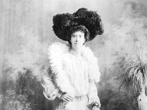 A 19th-century woman wears a feathered hat and boa for her portrait.