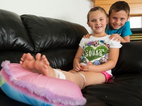 Kennedy Field, 6, and her brother Peyton Field, 7, pose for a photo at their home, in Edmonton on Friday Aug. 19, 2016. Kennedy needed 37 stitches and surgery to close a huge cut on her leg that she received while playing on a make-shift slip and slide. Immediately after the accident Payton ran and grabbed a first aid kit and was the one to flag down the ambulance. DAVID BLOOM/Postmedia