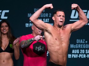 Welterweight Nate Diaz flexes for the fans while leaving the stage following weigh-ins for his Saturday UFC 202 mixed martial arts bout against Conor McGregor, Friday, Aug. 19, 2016, in Las Vegas. (L.E. Baskow/Las Vegas Sun via AP)