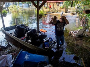 Daniel Stover, 17, wipes his head as he helps Laura Albritton, rescue personal belongings in Sorrento, La., Saturday, Aug. 20, 2016.  Louisiana continues to dig itself out from devastating floods, with search parties going door to door looking for survivors or bodies trapped by flooding.  (AP Photo/Max Becherer)
