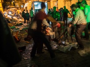People carry an injured man on the site of an explosion August 20, 2016 in Gaziantep following a late night militant attack on a wedding party in southeastern Turkey.  The governor of Gaziantep said 22 people are dead and 94 injured in the late night militant attack.  ( AFP PHOTO / AHMED DEEBAHMED DEEB/AFP/Getty Images)