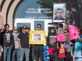 Family, friends and supporters for Colten Boushie hold signs during a rally outside of the Saskatchewan Provincial Court in North Battleford,Thursday, August 18, 2016. People rally outside a Saskatchewan courthouse Thursday where a farmer accused of fatally shooting a First Nations man is to make an appearance. (THE CANADIAN PRESS/Liam Richards)