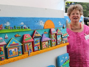 St. Marys artist Nancy Plummer shows off one of her mixed media beach scenes up for sale at ARTZscape by the Bay Saturday. Close to 100 artisans participated in the annual juried art show and sale held at Centennial Park this weekend in support of the Pathways Health Centre for Children. Barbara Simpson/Sarnia Observer/Postmedia Network