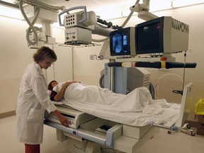 X-Ray technologist Charlene Kozak (left) operates a Fluoroscopy machine.