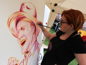 Sarnia artist Cat Cabajar paints a portrait of Tragically Hip front man Gord Downie during That Night in Sarnia held in Canatara Park Saturday. About 10,000 people attended the local viewing party to watch The Hip's final concert in the "Man Machine Poem" tour being broadcasted live from Kingston. (Barbara Simpson/Sarnia Observer)