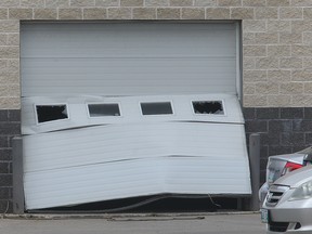 Damage is seen to the overhead door of the Birchwood Collision Centre at 1 Owen Street in Winnipeg, Man. Sunday August 21, 2016 following an overnight stolen vehicle and crime spree. A 29 year old male has been arrested and charged with numerous offences.