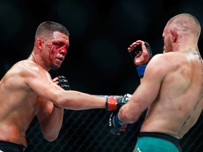A bloodied Nate Diaz (left) throws a punch at Conor McGregor during their rematch at UFC 202 at T-Mobile Arena on August 20, 2016 in Las Vegas. (Photo by Steve Marcus/Getty Images)