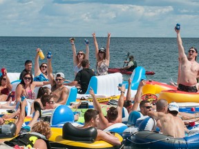 People celebrate as they start the Float Down at Lighthouse Beach in Port Huron, Mich., Sunday, Aug. 21, 2016. Thousands of people gathered for the event and floated down the St. Clair River. (Mark R. Rummel/The Times Herald via AP)