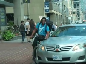 A frame grab from a video posted to YouTube on Aug. 20, 2016 showing a Toronto cab striking cyclist. (YouTube)
