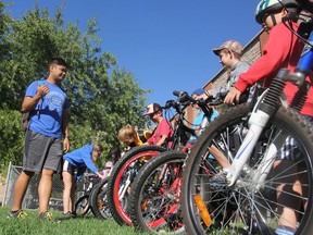 YMCA summer bike camp counsellors Edward Itliong and Madi Kitts address their charges before having them put on their helmets and head out onto the streets in Kingston on Monday. The camp teaches the kids how to safely ride on city streets. (Michael Lea/The Whig-Standard)