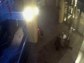 In this Dec. 23, 2015 image made from security video provided by H&R Reit MSLP, security guard Nathaniel McNeil, second right, tackles a machete-wielding man in Toronto. (H&R REIT MSLP VIA AP)