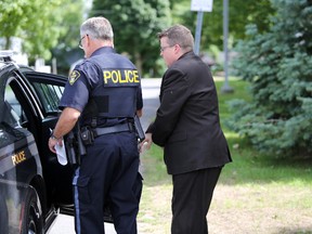 Kevin Wagar is loaded into a waiting police car after he was sentenced to five and a half years in prison for fraud. (Meghan Balogh/Postmedia Network)