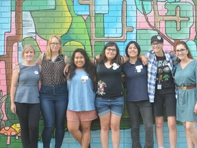 Left to right, Taylor Burnett, artist mentor, Selena Wells, artist mentor, and students Melissa Colindres, Dana Cosman, Shuko Wada, Brooke Watson and Miranda Houben stand in front of their completed mural project. (Photo courtesy of Reileigh Biggs)