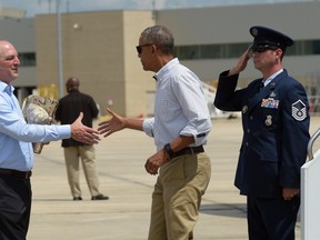 President Barack Obama reaches to shake hands with Louisiana Gov. John Bel Edwards, after arriving on Air Force One at Baton Rouge Metropolitan Airport in Baton Rouge, La., Tuesday, Aug. 23, 2016. Obama is traveling to the area to survey the flood damage. (AP Photo/Susan Walsh)